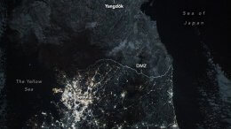 NASA nighttime image of the Korean Peninsula showing South Korea glowing with city lights while North Korea remains largely dark beyond the DMZ.